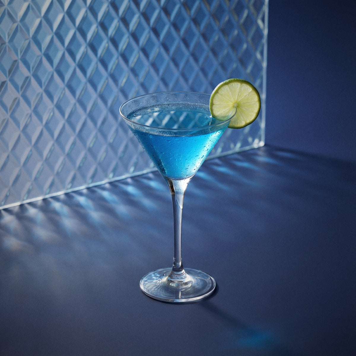 Blue 1575 daiquiri cocktail in a martini glass with a lime wedge on a dark surface.