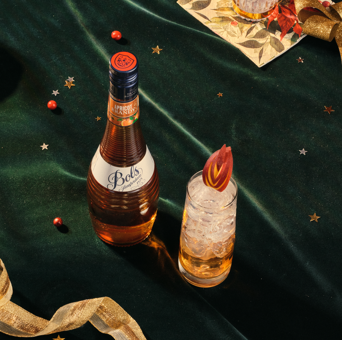 Bols apricot brandy bottle with a cocktail on a dark green fabric background