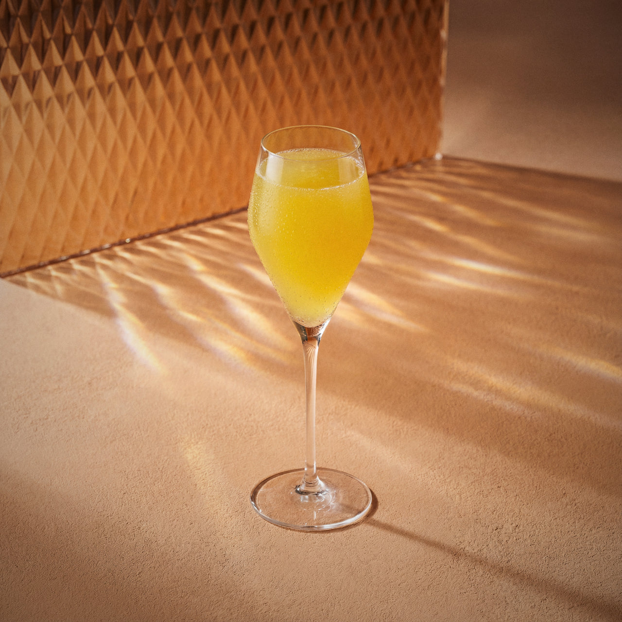 French 75 cocktail with gin in a flute glass on a textured surface